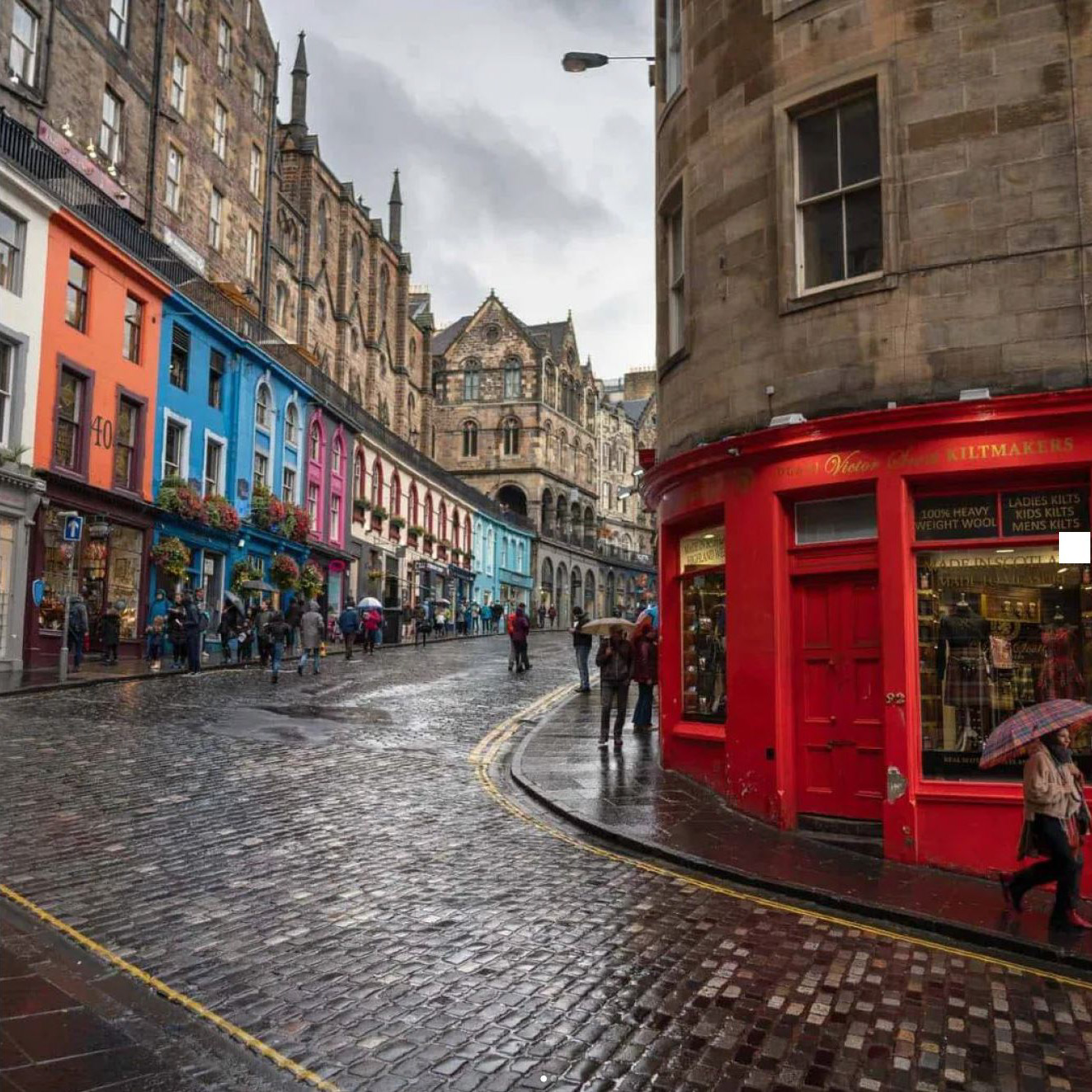 image of a european street with colorful storefronts and cobble stone streets in the rain
